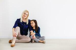 contento familia a hogar. sonriente mujer y su pequeño hija tener divertido a hogar foto