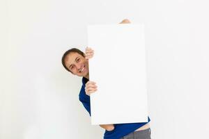 blanco lienzo. Copiar espacio en lona tablero para imagen o mensaje. joven hombre mirando a Bosquejo póster y en pie terminado gris antecedentes. foto