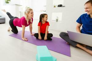 family mother and child daughter are engaged in fitness, yoga, exercise at home photo