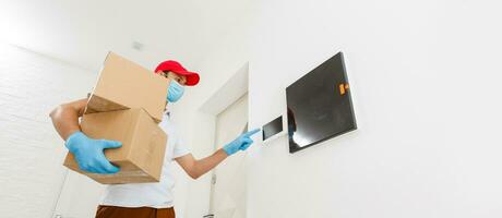 Courier in protective mask and medical gloves delivers takeaway food. Delivery service under quarantine, disease outbreak, coronavirus covid-19 pandemic conditions. photo