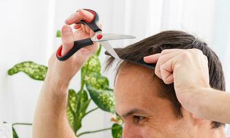 coronavirus de los hombres Corte de pelo a hogar, en línea peluquería tutoría en un ordenador portátil foto