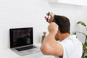 coronavirus mens haircut at home, online hairdressing tutoring on a laptop photo