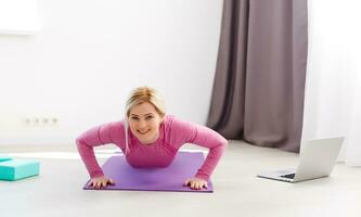 Beautiful young woman doing yoga at home. photo