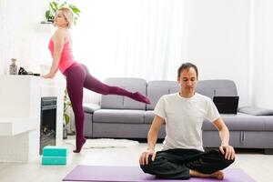 Pareja haciendo ejercicios a hogar. yoga concepto. foto