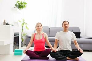 Young man and woman woman doing exercise in the sunny room photo