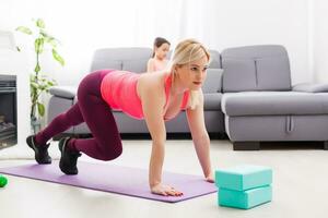 Fitness woman exercising on the floor at home photo