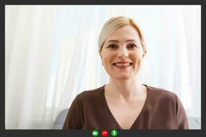 Happy young woman blogger applicant teacher sit at home office look at camera doing online job interview during video chat conference call record vlog teaching on webinar in app, webcam view photo