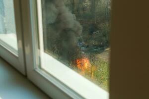 Wildfire near houses, view from the apartment window photo