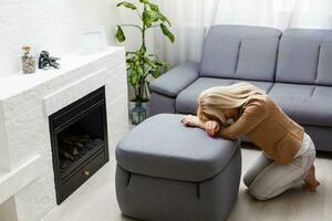 a woman on her knees prays at home photo