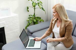 Portrait of happy skilled middle aged woman life coach, business consultant, psychologist or medical advisor smiling joyfully at camera, working on laptop, enjoying her job, helping people online photo