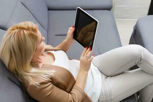 Young beautiful female student using a tablet computer while studying and organizing her time photo