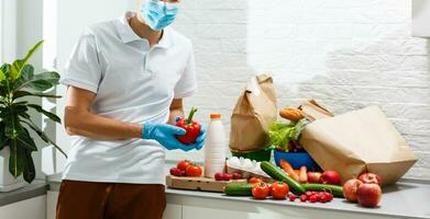 Man with fresh products at table indoors, closeup. Food delivery service photo