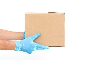 Delivery man holding cardboard boxes in medical rubber gloves and mask. copy space. Fast and free Delivery transport . Online shopping and Express delivery . Quarantine photo