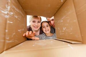 Happy family opening cardboard box - moving concept photo