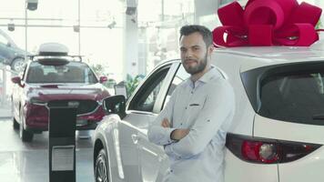 Handsome male driver holding car keys to his new auto at the dealership video