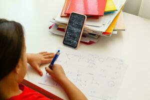 Distance learning online education, little girl writes formulas photo