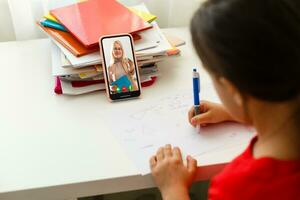 Distance learning online education, little girl writes formulas photo