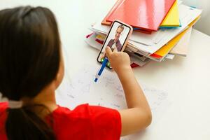 Distance learning online education, little girl writes formulas photo