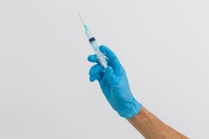Hand holding syringe isolated on white photo