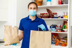 coronavirus pandemic man in protective mask and gloves with food purchases photo