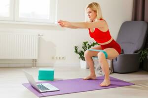 Young woman exercising at home in a living room. photo