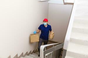 Delivery man holding cardboard boxes in rubber gloves and mask. Online shopping and Express delivery photo