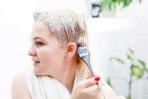 Hair dyeing in the domestic bathroom. One woman only photo