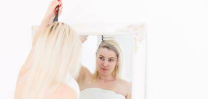 A middle-aged woman dyes her hair at home, indoors photo