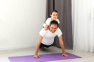 father and daughter do fitness at home, sports training photo