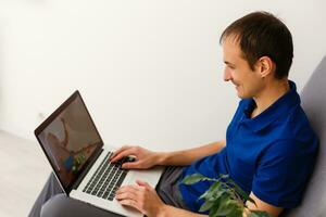 Young man working absorbed on laptop at home copy space photo