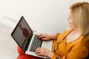 Cropped image of young female student attending online lecture on laptop at desk photo