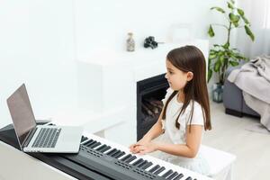 pequeño niña aprendizaje el piano durante cuarentena. coronavirus concepto. foto