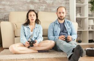 Young couple playing video games in living room. photo