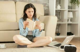 mujer sentado en piso leyendo un libro. foto