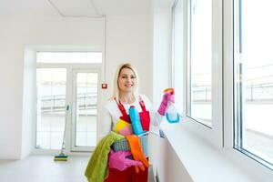 Woman cleaning windows at home with detergents cleaner photo