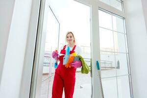 Beautiful young woman makes cleaning the house. Girl rubs dust. photo