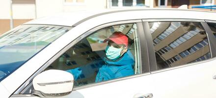 Close-up photos of drivers wearing masks to protect against dust and the spread of the flu. Covid 19. Inside the car front