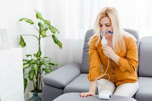 Portrait of adult woman using steam vapor inhaler nebulizer doing aerosol inhalation medicine treatment at home or hospital flu and asthma bronchitis virus healing photo