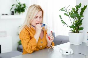 woman makes inhalation nebulizer at home. holding a mask nebulizer inhaling fumes spray the medication into your lungs sick patient. self-treatment of the respiratory tract using inhalation nebulizer photo