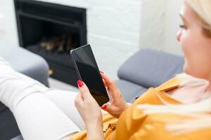 Woman at home relaxing on sofa couch reading email on the tablet computer wifi connection photo