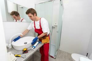 plumber service. Plumber portrait near wash basin siphon installation. photo