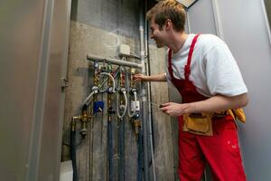 maintenance technician checking pressure meters for house heating system. photo