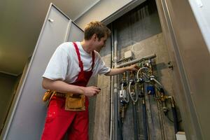 plumber installing pressure meter for house heating system photo