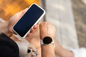 phone in the hands of a girl and a smart watch on her hand mockup photo