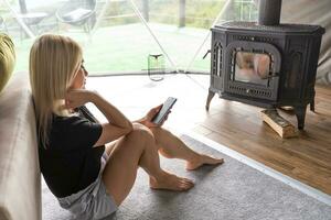 Shot of a beautiful woman using a smartphone while relaxing at home photo