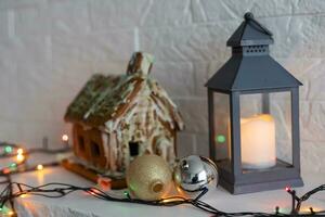 handmade gingerbread house with glaze standing on table with tablecloth and decorations. Holiday mood photo