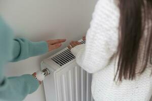 hands of a little girl near the radiator photo