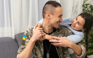 Soldier in Ukrainian military uniform hugging his daughter. Family reunion photo
