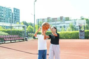 niños y Deportes. Adolescente niña jugando baloncesto en el patio de juegos. foto