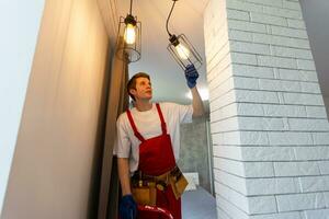 man changing led ceiling lamp in new house photo